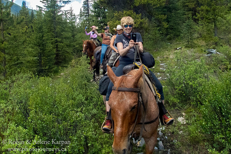 Taking photos with smartphone on trail ride, Banff National Park, Alberta, Canada