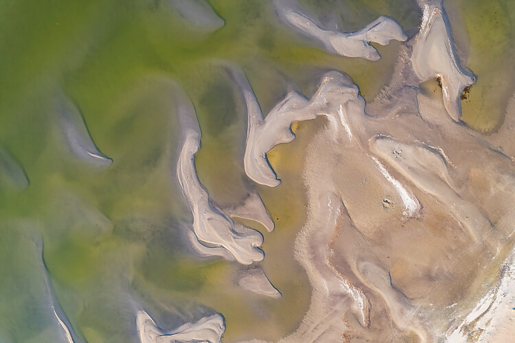 Sandbars on a lakeshore are used for abstract photography.