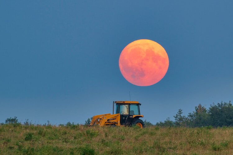 Moon rising over tractor, Saskatchewan.