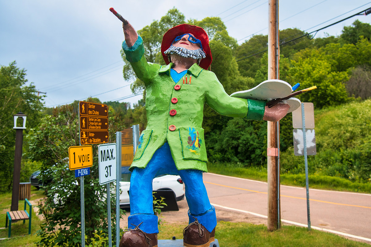 Painter sculpture next to the Pont du Faubourg, L'Anse-Saint-Jean, Quebec.